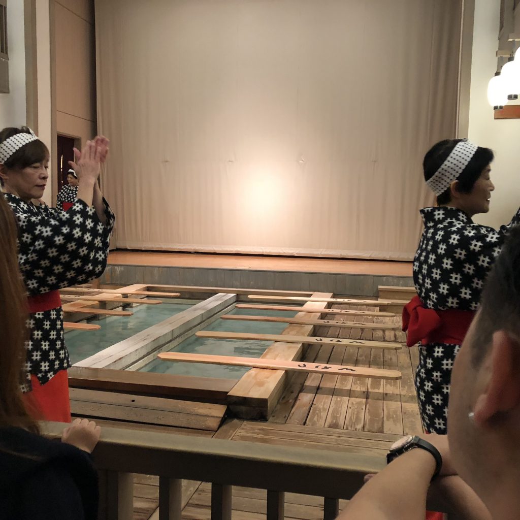 A photo of the women walking around the pool in a circle clapping their hands.