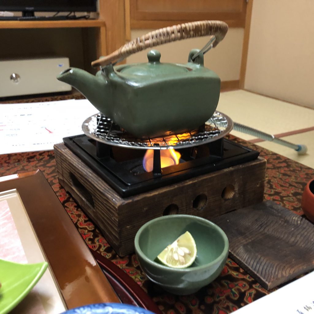 A green teapot on a brazier.