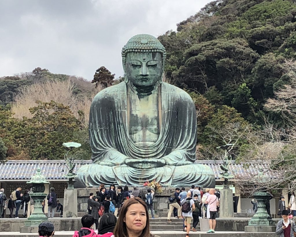 A photo of the daibutsu from the front. There are people all over.