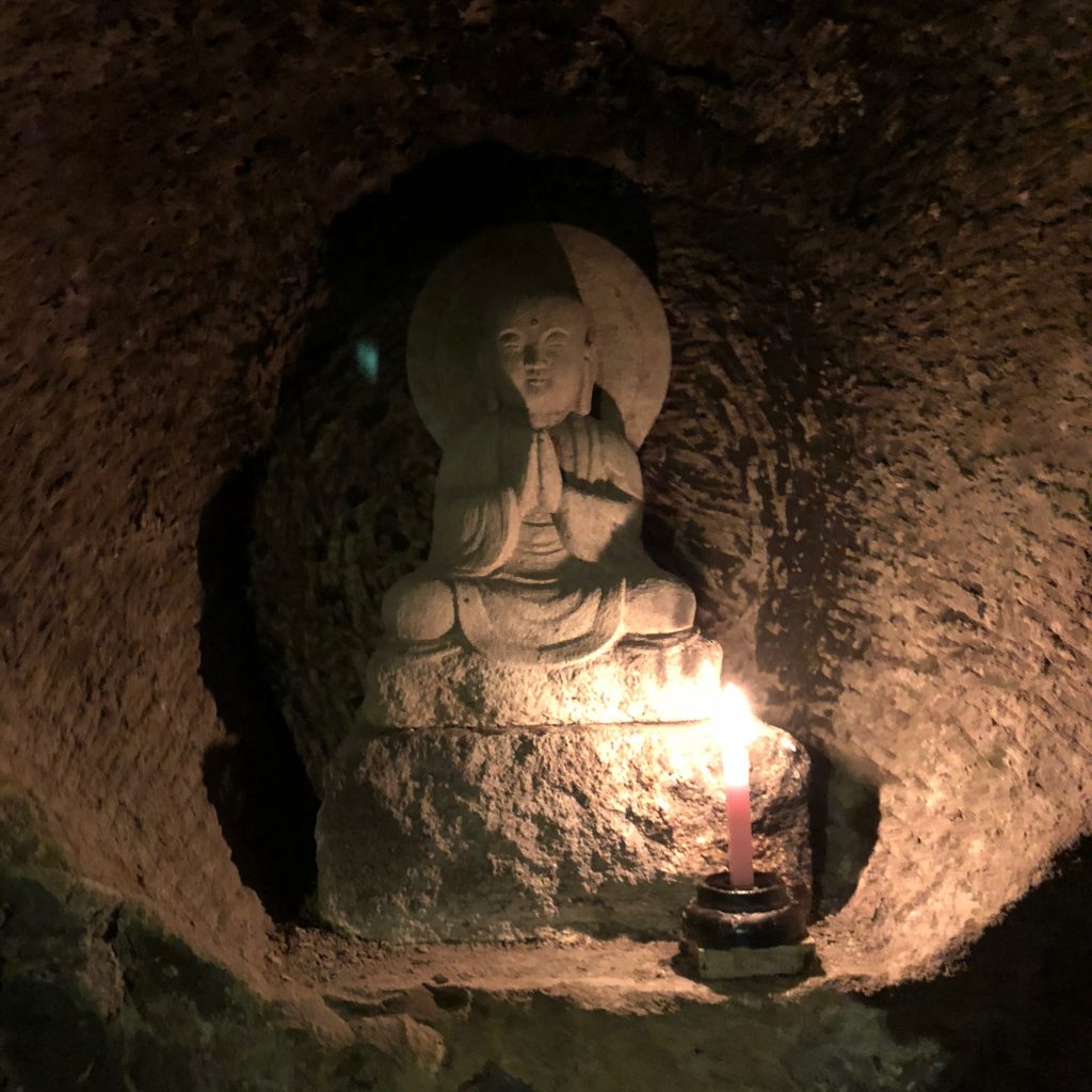 a small statue of jizo set into the wall.