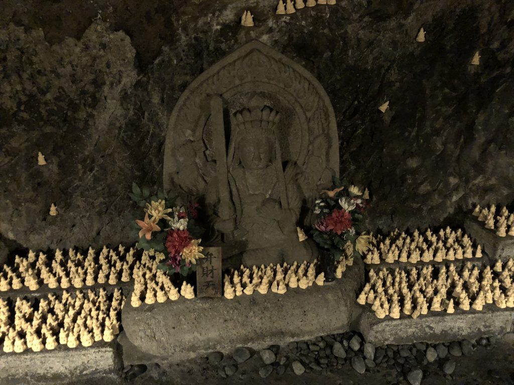 A small statue of Benzaiten. There are hundreds of tinier votive statues scattered around her.