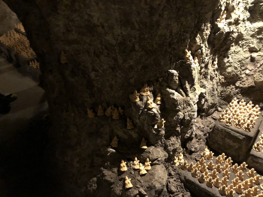 Offerings stuffed into the crevices of the cave walls.