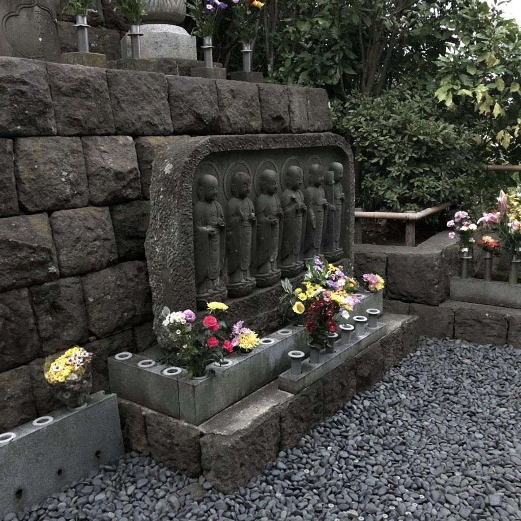 A statue of several Jizo in a row, each in a different position.