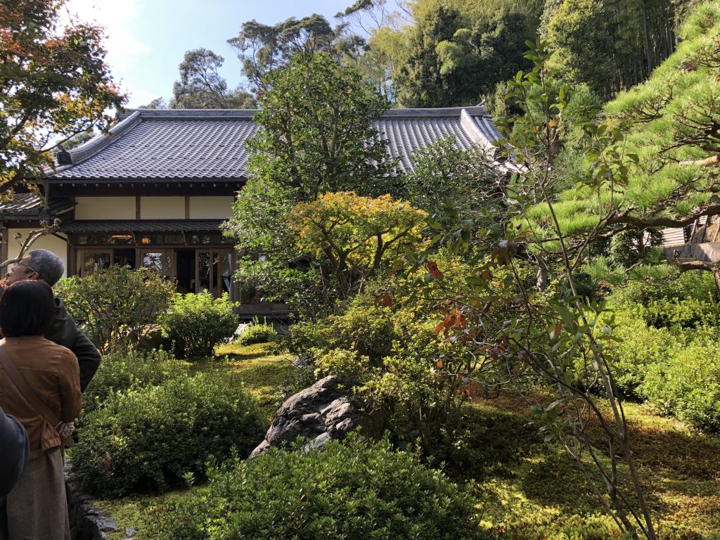 A traditional temple hall surrounded by trees.