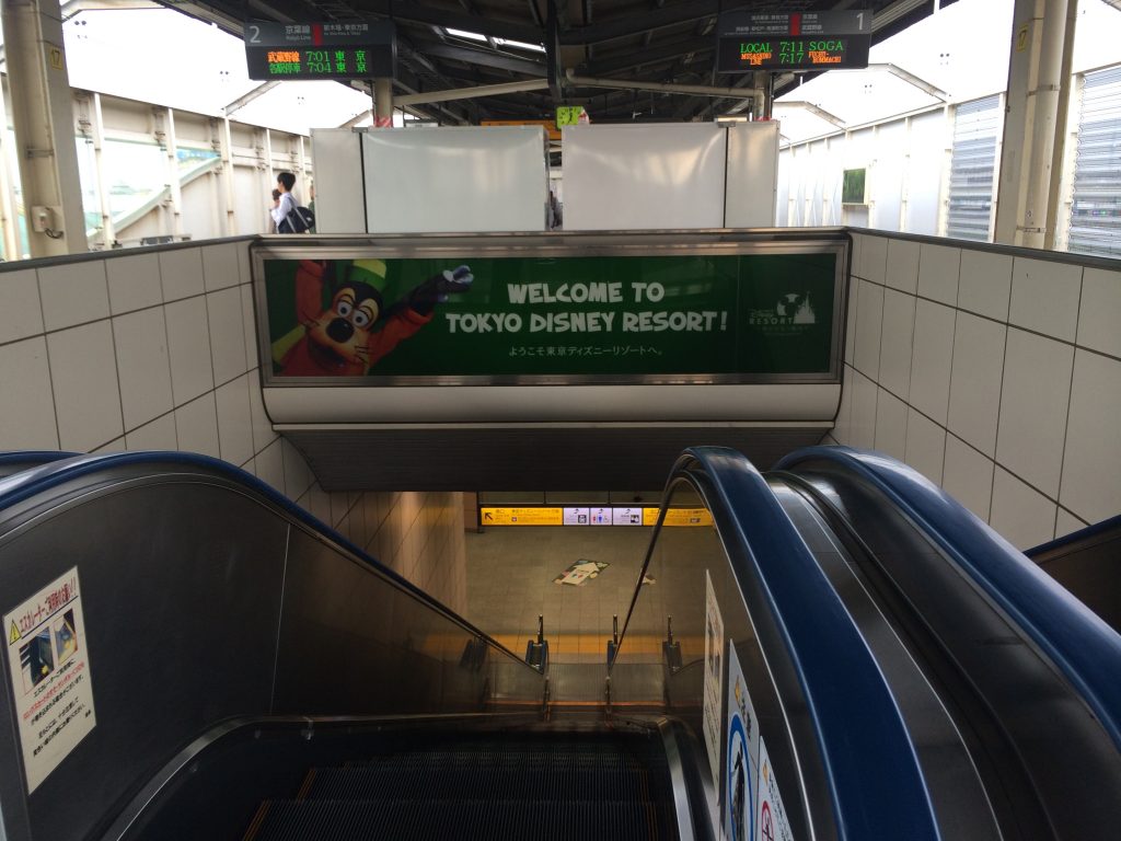 A sign welcoming guests to Tokyo Disneyland in the train station.