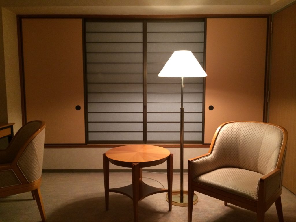 A picture of a hotel room. It has traditional Japanese sliding windows.