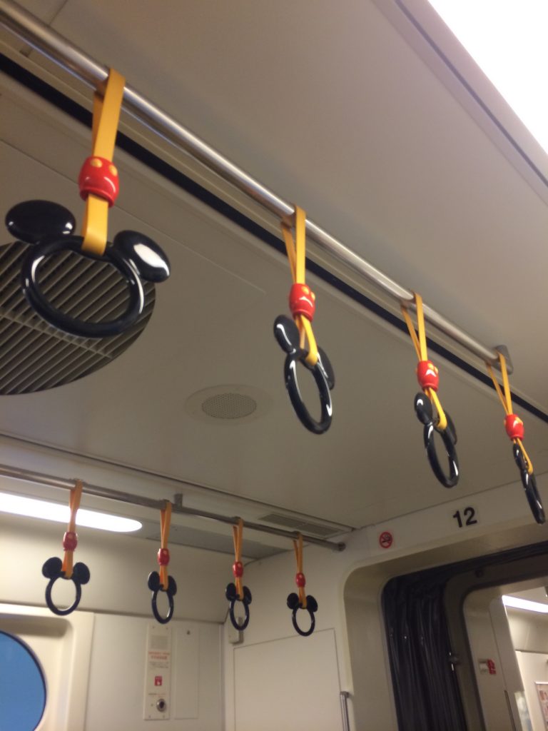 The hanging handles on this train are shaped like Mickey's head.