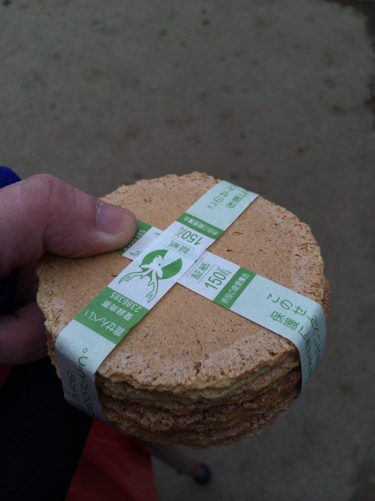 A stack of very flat deer crackers bound up in a paper ribbon.