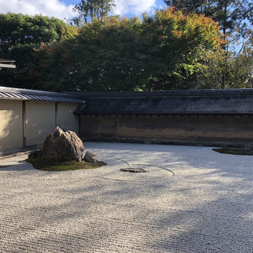 The left half of the garden. A bed of pebbles with a few large rocks on them, covered in moss.