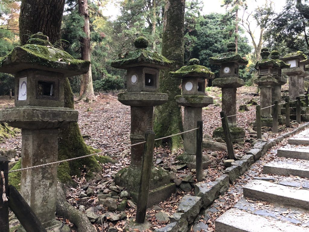 Stone lanterns on the left covered in moss.