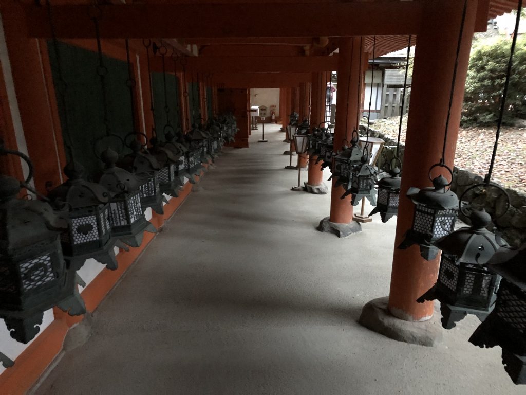 A hallway lined with metal hanging lanterns.